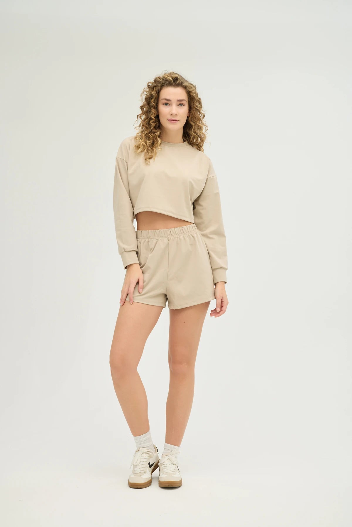 Bej Crop Sweatshirt Takım, modern tasarımı ve konforlu yapısıyla günlük şıklığınızı tamamlayan mükemmel bir seçenektir. Yumuşak ve nefes alabilir kumaşı sayesinde gün boyu rahat bir kullanım sunarken, ter emici özelliği ile spor yaparken serin ve kuru kalmanıza yardımcı olur.&nbsp;Oversize kesimiyle şık ve rahat bir görünüm sunan crop sweatshirt, elastik bel detaylı şort ile kombinlenerek hareket özgürlüğü sağlar. Minimalist tasarımı ve zamansız bej rengi sayesinde her türlü spor veya günlük kombinle kolayc
