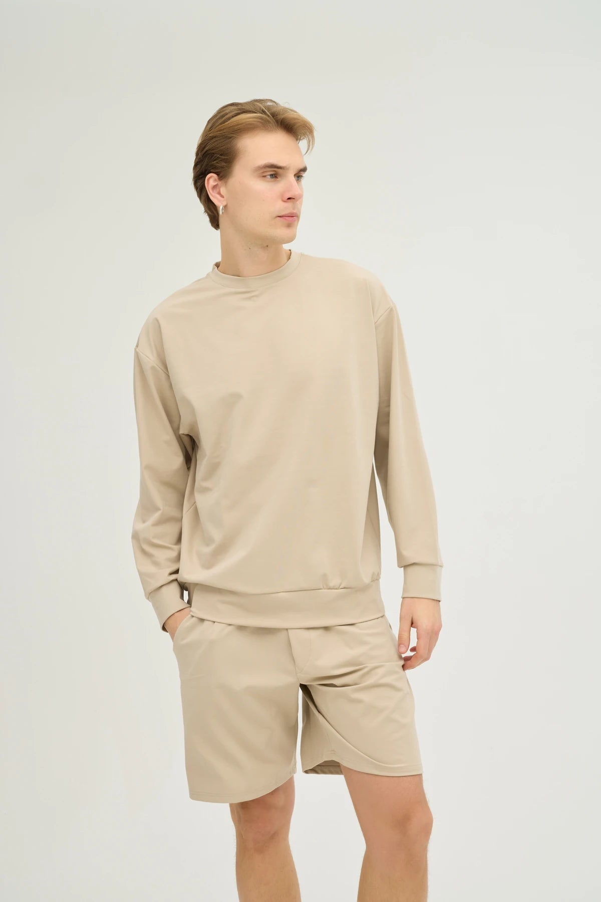 Bej Sweatshirt Takım, minimalist tasarımı ve üstün konforu bir araya getiren şık bir seçimdir. Oversize sweatshirt ve rahat kesimli şorttan oluşan bu takım, yumuşak ve nefes alabilir kumaşı ile gün boyu konfor sunar.