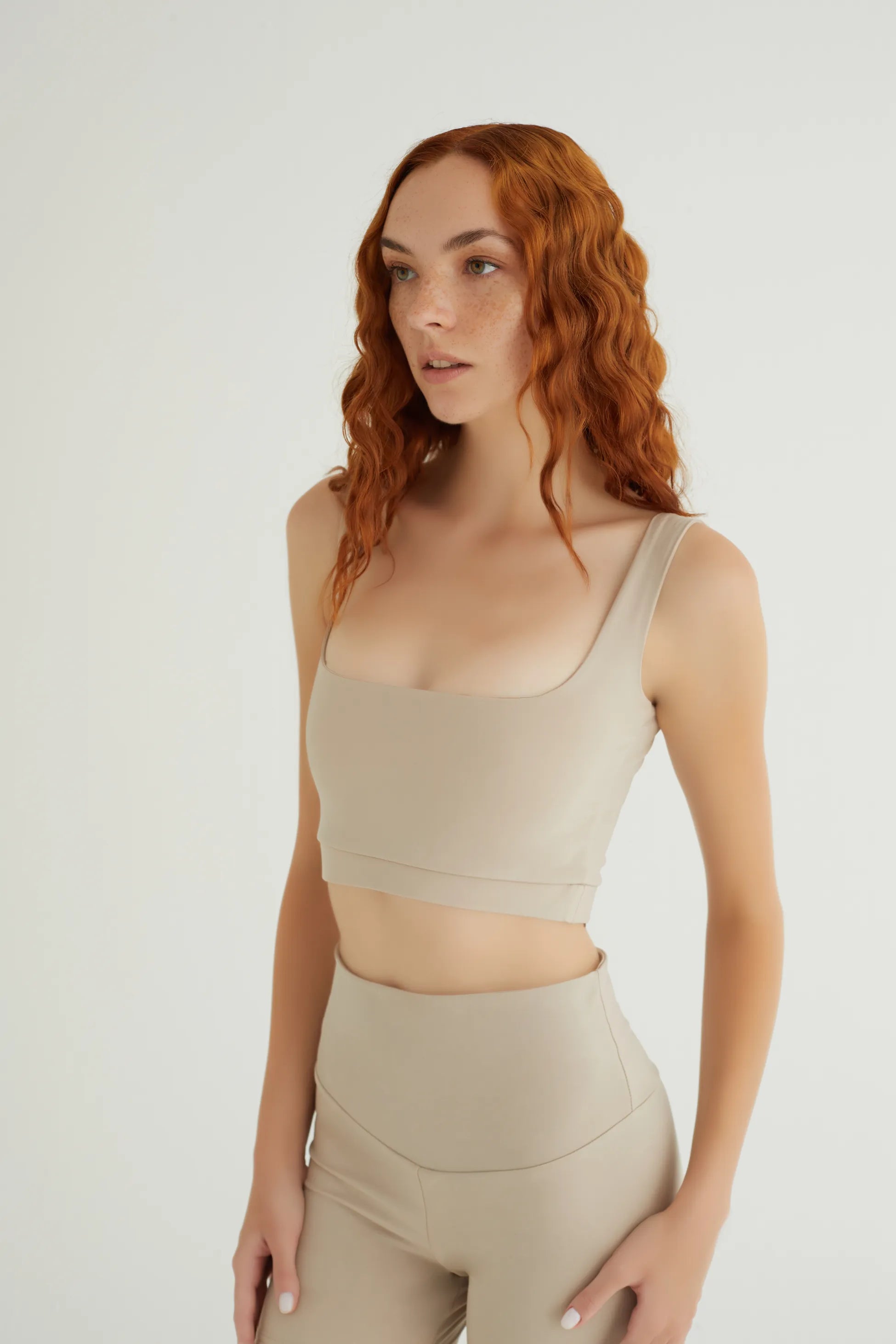 Comfortlux Bej Tank Top, 19 cm uzunluğundaki modern kesimiyle hem spor yaparken hem de günlük kullanımda şıklığınızı öne çıkarır. Hafif ve nefes alabilir kumaşı, yoğun aktivitelerde serin ve kuru kalmanıza yardımcı olur.&nbsp;Yumuşak dokusu ve esnek yapısı ile vücudu sararak hareket özgürlüğü sağlar, böylece yoga, pilates ve fitness gibi sporlar için mükemmel bir tercih haline gelir. Şık bej rengi, bu tank topu dolabınızın vazgeçilmez parçalarından biri yapacak. Hem rahatlığı hem de stilinizi bir arada suna