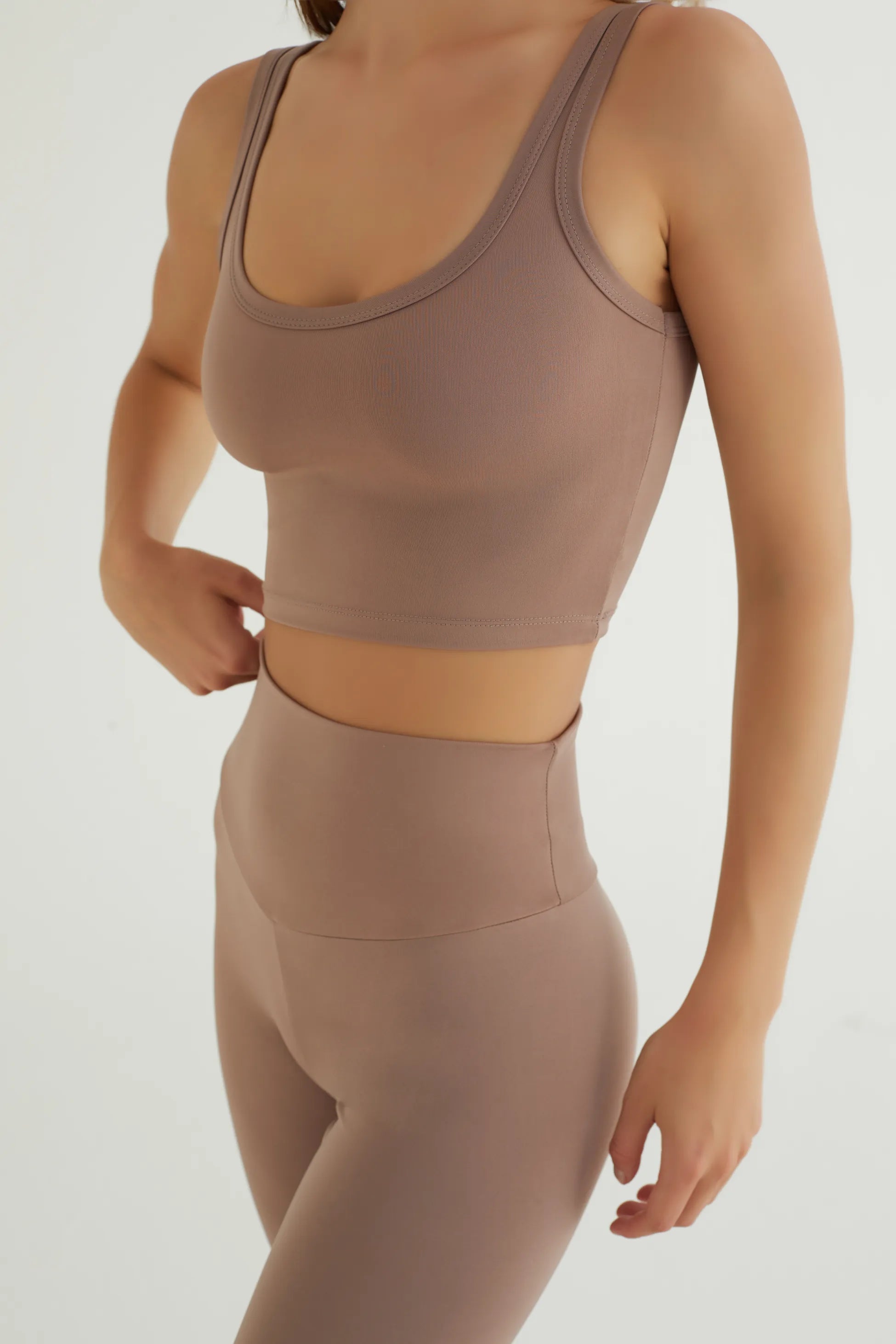 Comfortlux Taba Crop Atlet, spor yaparken veya günlük kombinlerinizde ideal bir rahatlık sunar. Yumuşak ve nefes alabilir kumaşı, ter emici özelliği sayesinde antrenmanlarınız boyunca serin ve kuru kalmanıza yardımcı olur.&nbsp;Minimalist tasarımı ve şık taba rengi ile her türlü alt giyimle kolayca kombinlenebilir. Esnek yapısı ve vücudu saran formu sayesinde yoga, pilates ve fitness gibi aktiviteler için mükemmel bir tercihtir. Hem şıklık hem de konfor arayanlar için tasarlanmış bu crop atlet, gardırobunuz