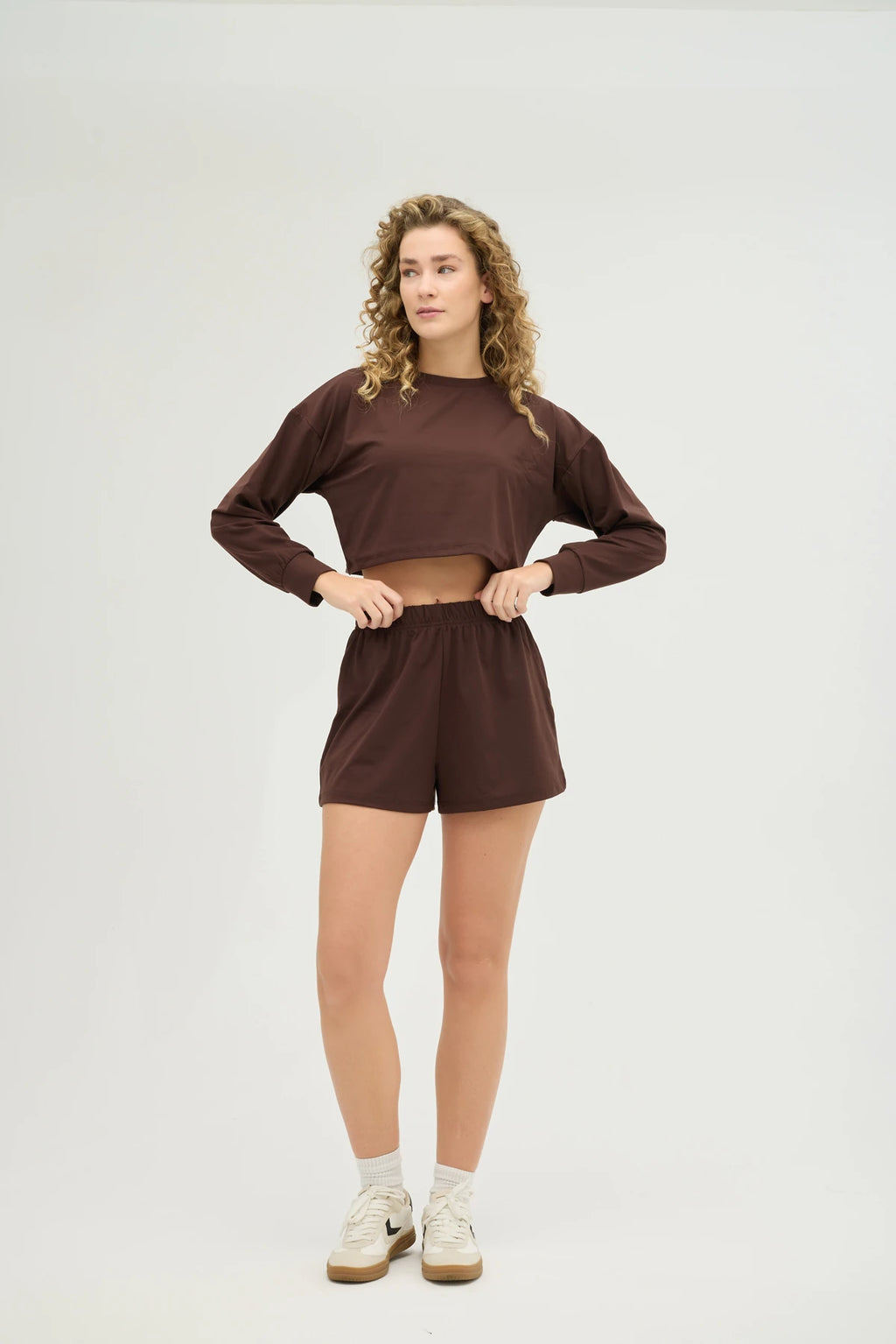 Crop Kahverengi Sweatshirt Takım, şıklık ve konforu bir araya getiren modern bir tasarıma sahiptir. Yumuşak dokulu, nefes alabilir kumaşı sayesinde gün boyu konforlu bir kullanım sunarken, spor aktiviteleri sırasında da hareket özgürlüğü sağlar.
