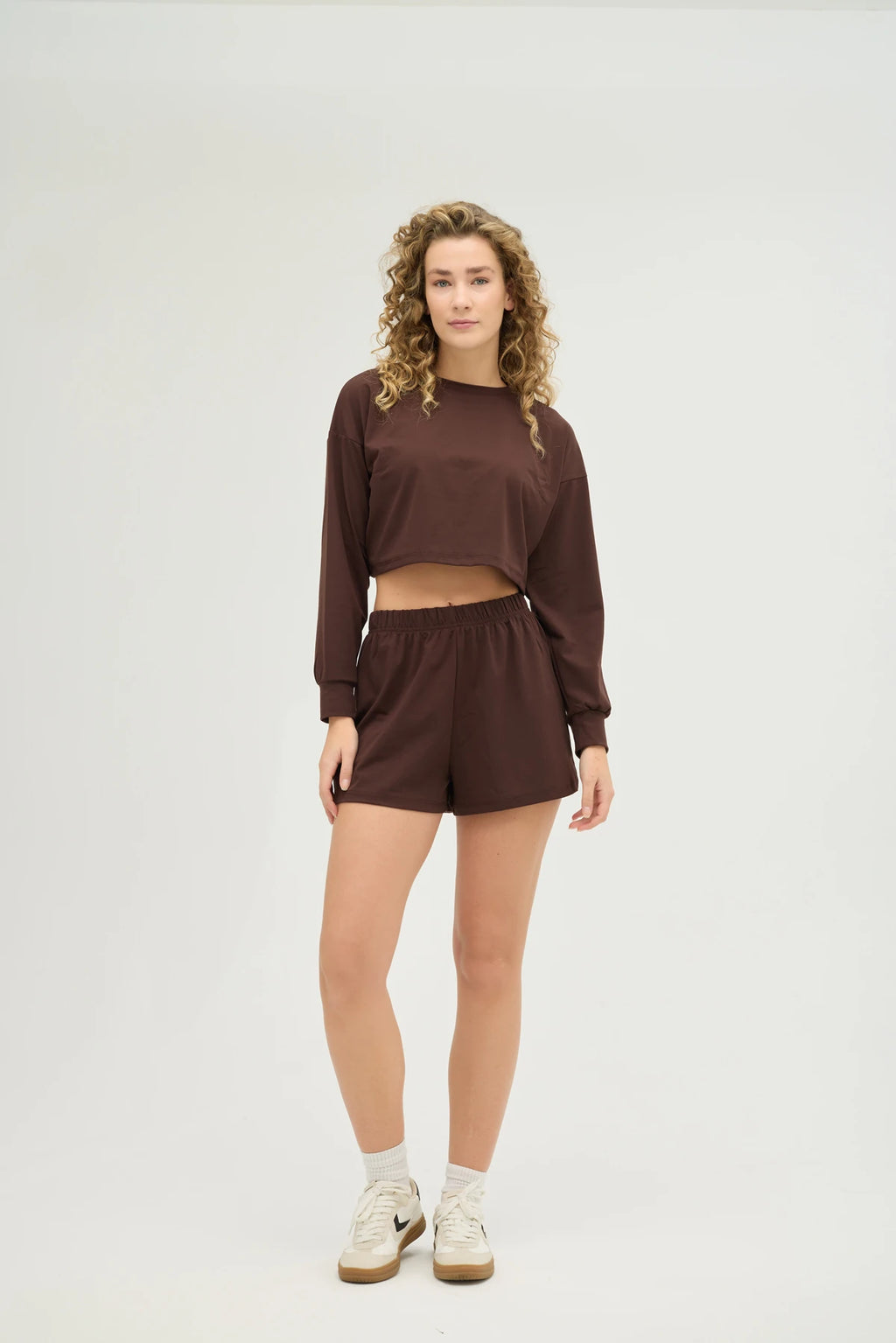 Crop Kahverengi Sweatshirt Takım, şıklık ve konforu bir araya getiren modern bir tasarıma sahiptir. Yumuşak dokulu, nefes alabilir kumaşı sayesinde gün boyu konforlu bir kullanım sunarken, spor aktiviteleri sırasında da hareket özgürlüğü sağlar.