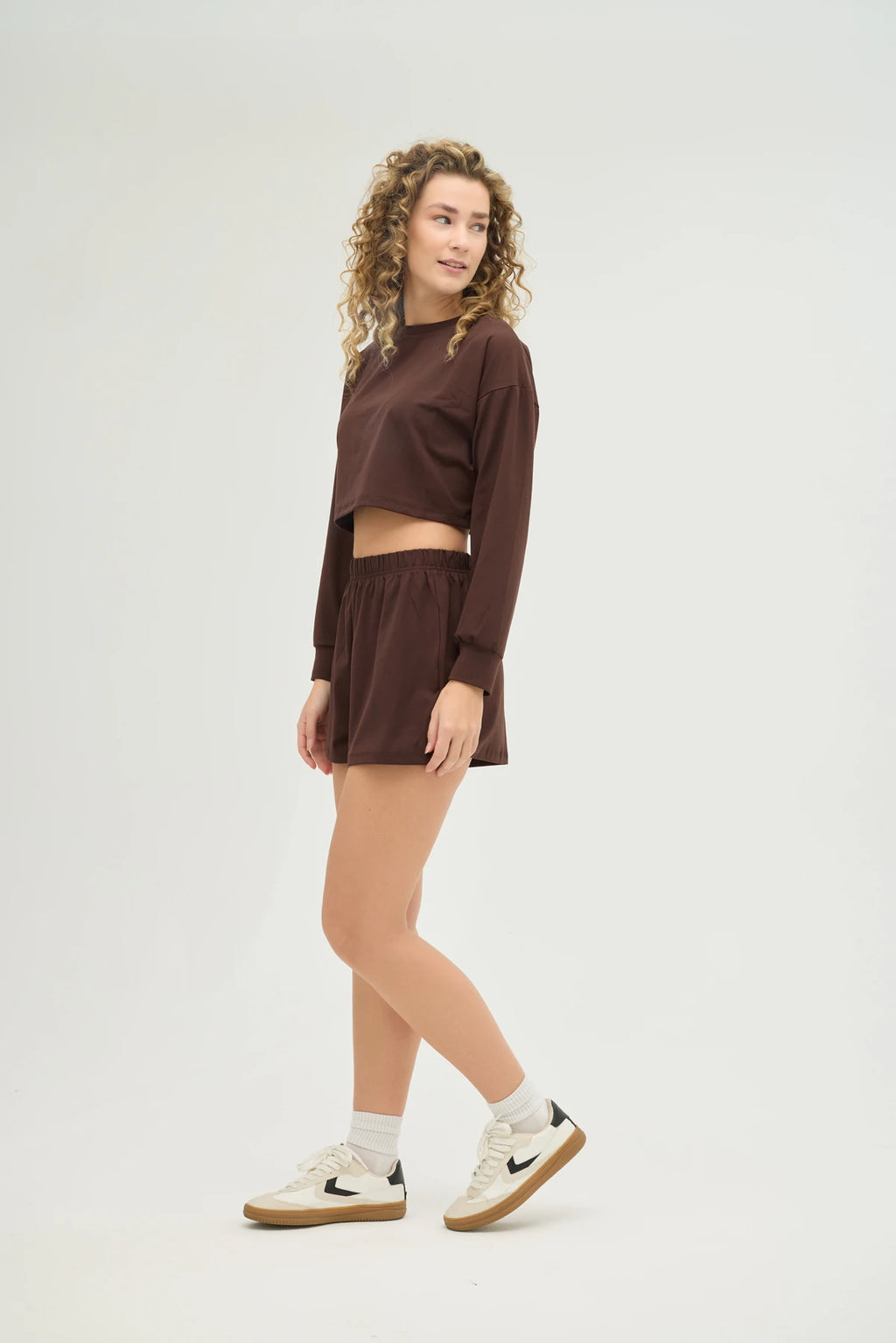 Crop Kahverengi Sweatshirt Takım, şıklık ve konforu bir araya getiren modern bir tasarıma sahiptir. Yumuşak dokulu, nefes alabilir kumaşı sayesinde gün boyu konforlu bir kullanım sunarken, spor aktiviteleri sırasında da hareket özgürlüğü sağlar.