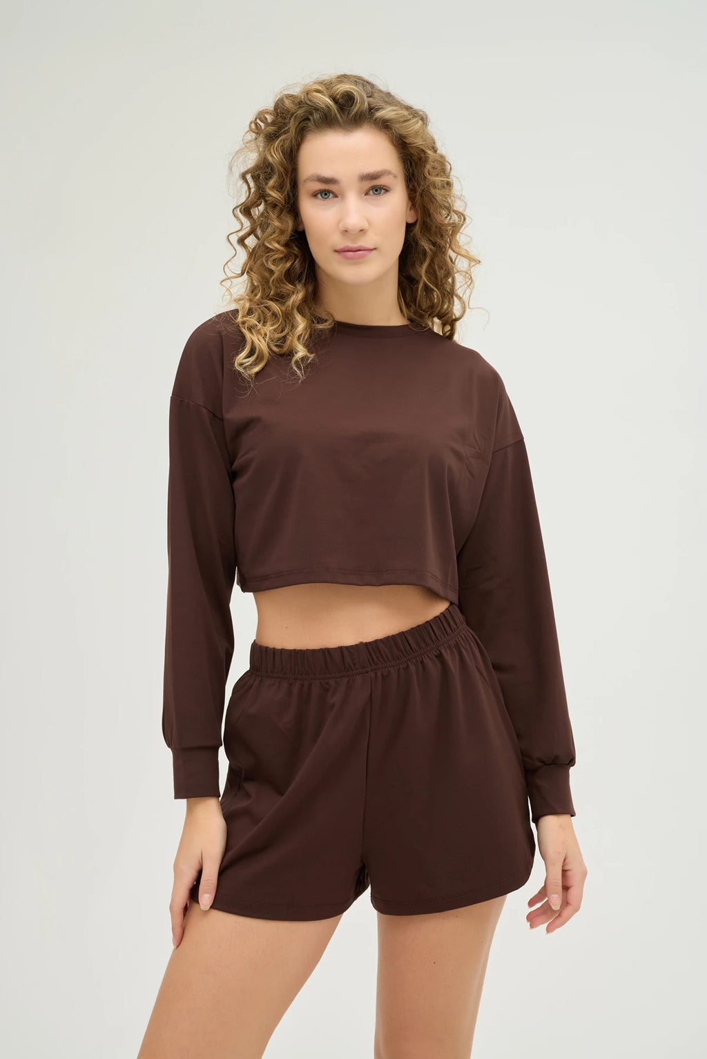 Crop Kahverengi Sweatshirt Takım, şıklık ve konforu bir araya getiren modern bir tasarıma sahiptir. Yumuşak dokulu, nefes alabilir kumaşı sayesinde gün boyu konforlu bir kullanım sunarken, spor aktiviteleri sırasında da hareket özgürlüğü sağlar.