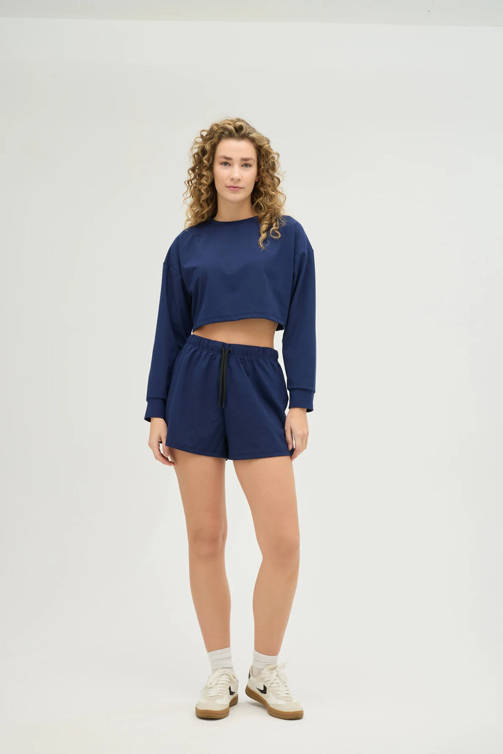 Crop Sweatshirt Takım – Lacivert, günlük stilinize ve spor kombinlerinize mükemmel uyum sağlayan modern ve konforlu bir seçenektir. Hafif ve nefes alabilir kumaşı, gün boyu rahat kalmanızı sağlarken, ter emici özelliği sayesinde spor yaparken serin ve kuru kalmanıza yardımcı olur.