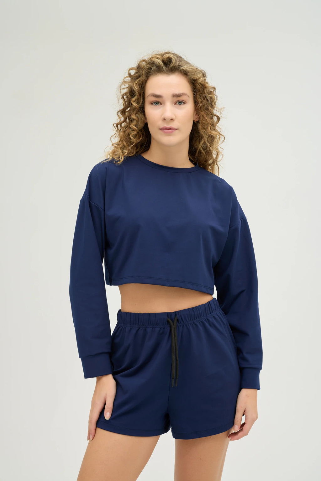 Crop Sweatshirt Takım – Lacivert, günlük stilinize ve spor kombinlerinize mükemmel uyum sağlayan modern ve konforlu bir seçenektir. Hafif ve nefes alabilir kumaşı, gün boyu rahat kalmanızı sağlarken, ter emici özelliği sayesinde spor yaparken serin ve kuru kalmanıza yardımcı olur.