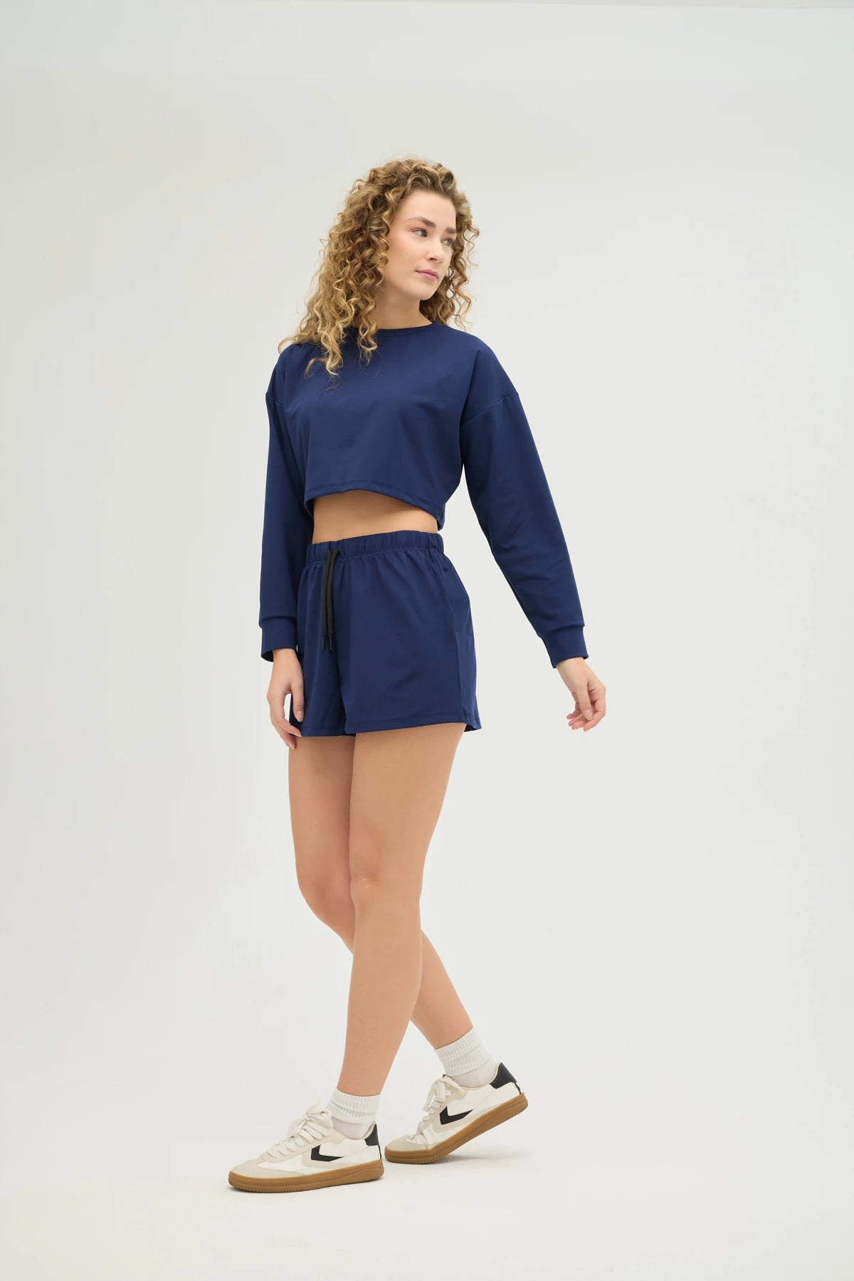 Crop Sweatshirt Takım – Lacivert, günlük stilinize ve spor kombinlerinize mükemmel uyum sağlayan modern ve konforlu bir seçenektir. Hafif ve nefes alabilir kumaşı, gün boyu rahat kalmanızı sağlarken, ter emici özelliği sayesinde spor yaparken serin ve kuru kalmanıza yardımcı olur.