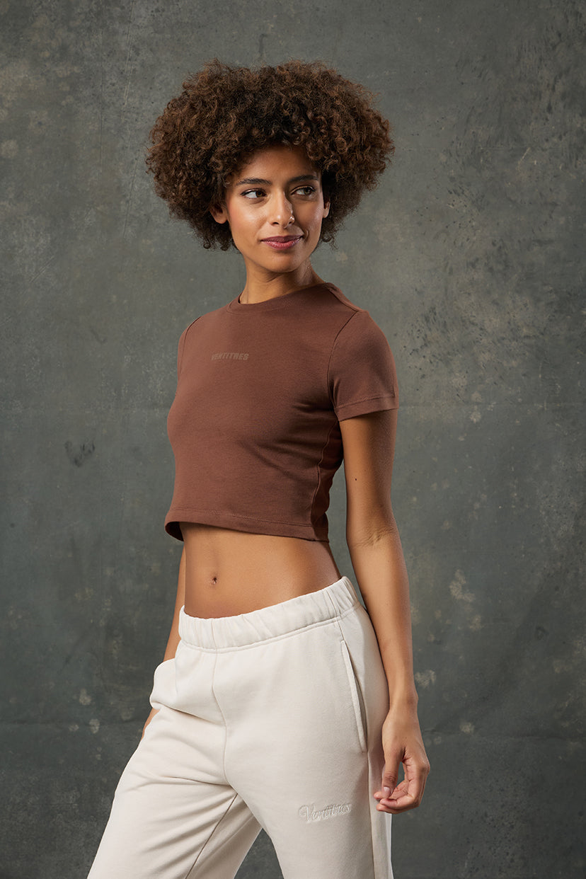 Luna Kahverengi Slim Fit Crop, vücuda oturan yapısı ve sıcak tonuyla stil sahibi bir görünüm sunar. Günlük kombinlerinize minimal ve zarif bir dokunuş katarken esnek kumaşıyla gün boyu rahatlık sağlar. Modern kesimiyle hem spor hem şehir stiline uyum gösterir.