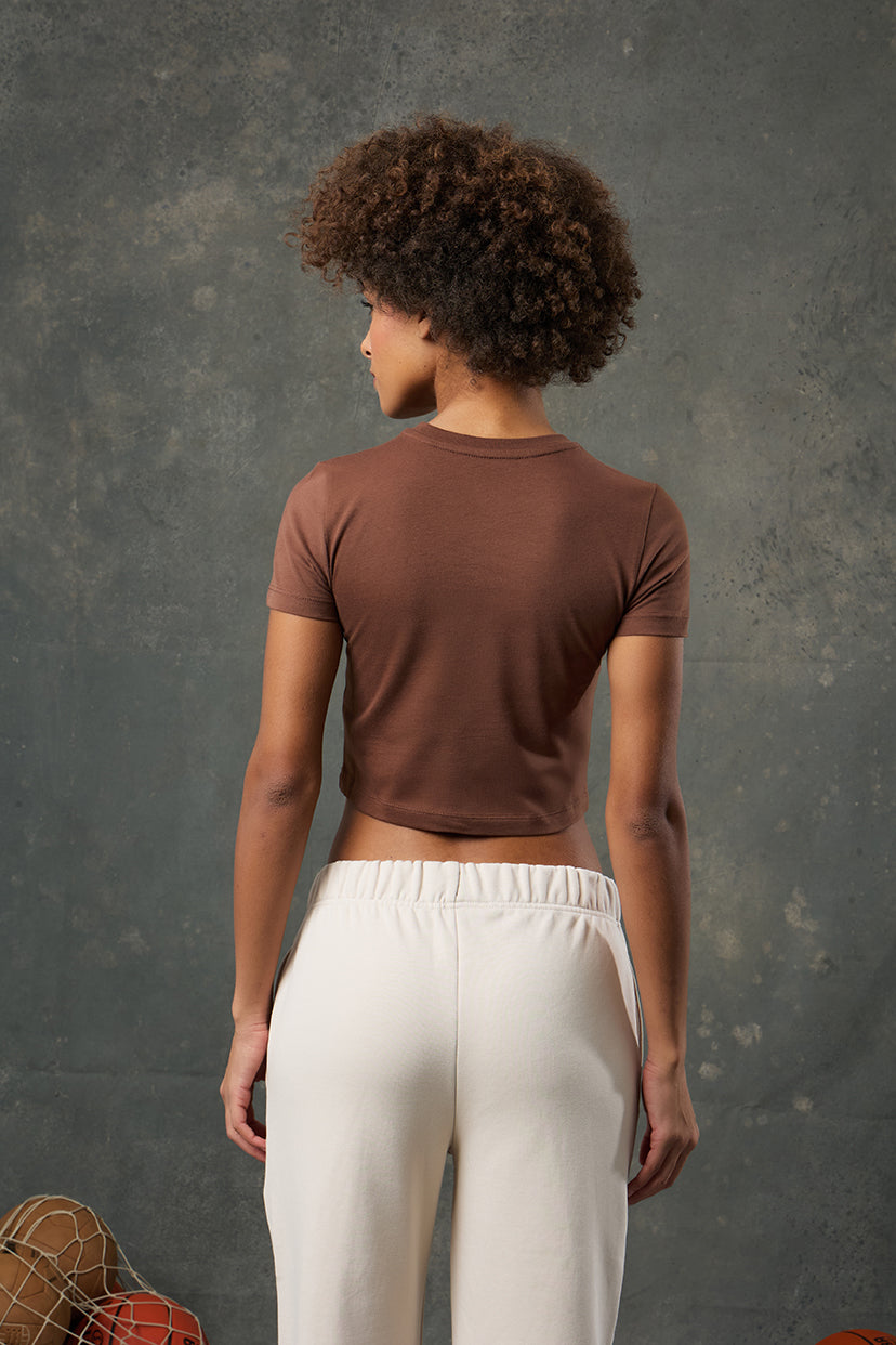 Luna Kahverengi Slim Fit Crop, vücuda oturan yapısı ve sıcak tonuyla stil sahibi bir görünüm sunar. Günlük kombinlerinize minimal ve zarif bir dokunuş katarken esnek kumaşıyla gün boyu rahatlık sağlar. Modern kesimiyle hem spor hem şehir stiline uyum gösterir.