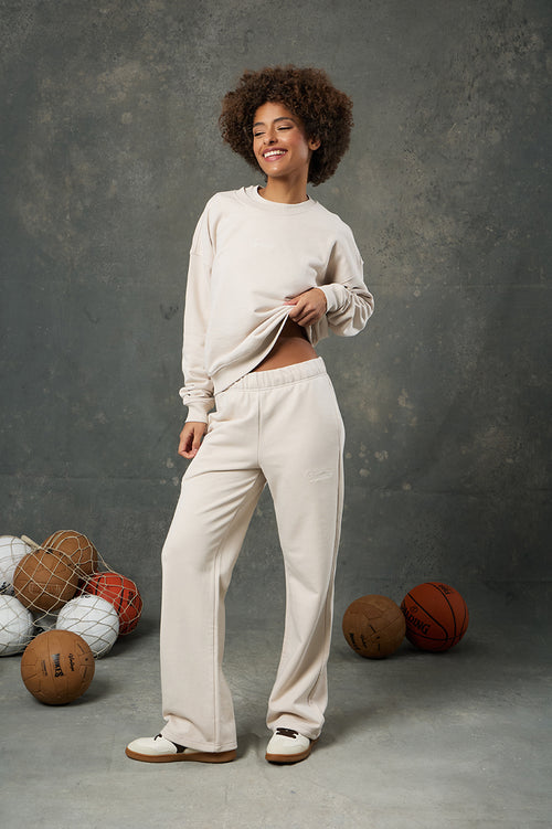 Urban Bej Kadın Eşofman Altı, yalın şıklığı ve rahatlığı bir araya getiren zamansız bir parça. Modern kesimiyle vücuda dengeli bir şekilde otururken, geniş paça yapısı sayesinde gün boyu konfor sunar. Yumuşacık dokulu kumaşı, hafifliğiyle öne çıkar ve cildinize nazikçe temas eder. Bej rengiyle sade ama sofistike bir görünüm sunan bu eşofman altı, gardırobunuzdaki farklı renk ve stillerle kolayca kombinlenebilir. Gerek evde dinlenirken gerek dışarıda günlük kombinlerde tarzınızı yansıtmak için ideal bir seçe