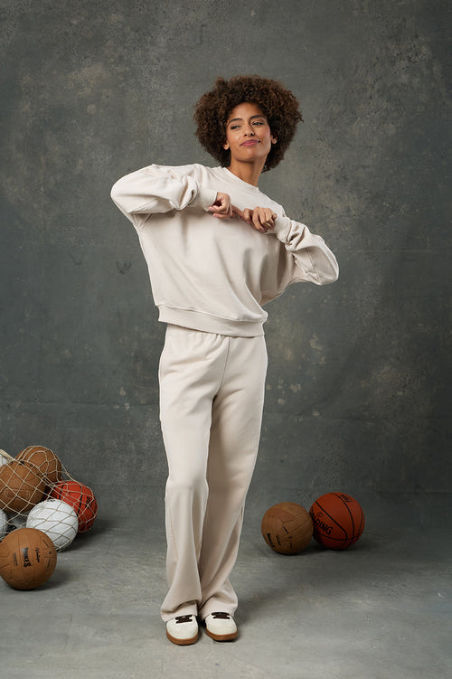 Urban Bej Kadın Eşofman Altı, yalın şıklığı ve rahatlığı bir araya getiren zamansız bir parça. Modern kesimiyle vücuda dengeli bir şekilde otururken, geniş paça yapısı sayesinde gün boyu konfor sunar. Yumuşacık dokulu kumaşı, hafifliğiyle öne çıkar ve cildinize nazikçe temas eder. Bej rengiyle sade ama sofistike bir görünüm sunan bu eşofman altı, gardırobunuzdaki farklı renk ve stillerle kolayca kombinlenebilir. Gerek evde dinlenirken gerek dışarıda günlük kombinlerde tarzınızı yansıtmak için ideal bir seçe