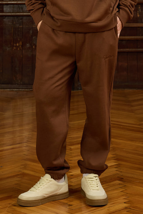 Urban Flow Kahverengi Eşofman Altı, stil sahibi erkekler için konfor ve şıklığı bir araya getiriyor. Doğal tonların sıcaklığına sahip bu parça, yumuşak dokulu kumaşıyla gün boyu rahatlık sunarken, yüksek bel ve elastik paça detaylarıyla sportif bir duruş sergiler. Geniş yan cepleri sayesinde pratik kullanım imkânı sağlarken, salaş yapısı hareket özgürlüğü sunar. Sokak stiline modern bir dokunuş katan bu eşofman altı, özellikle oversize sweatshirt’lerle veya basic tişörtlerle kombinlendiğinde zahmetsiz bir s