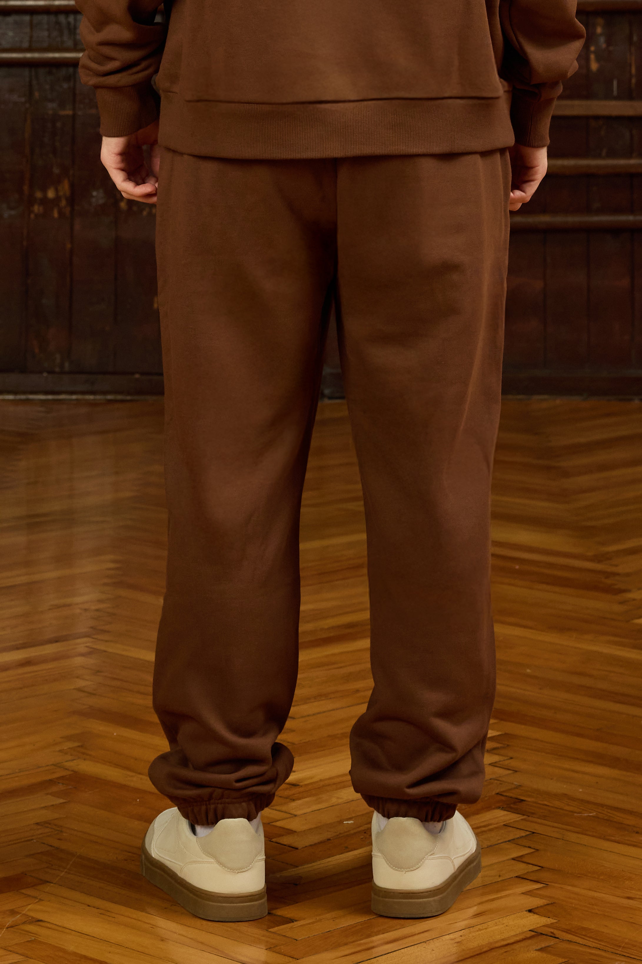 Urban Flow Kahverengi Eşofman Altı, stil sahibi erkekler için konfor ve şıklığı bir araya getiriyor. Doğal tonların sıcaklığına sahip bu parça, yumuşak dokulu kumaşıyla gün boyu rahatlık sunarken, yüksek bel ve elastik paça detaylarıyla sportif bir duruş sergiler. Geniş yan cepleri sayesinde pratik kullanım imkânı sağlarken, salaş yapısı hareket özgürlüğü sunar. Sokak stiline modern bir dokunuş katan bu eşofman altı, özellikle oversize sweatshirt’lerle veya basic tişörtlerle kombinlendiğinde zahmetsiz bir s